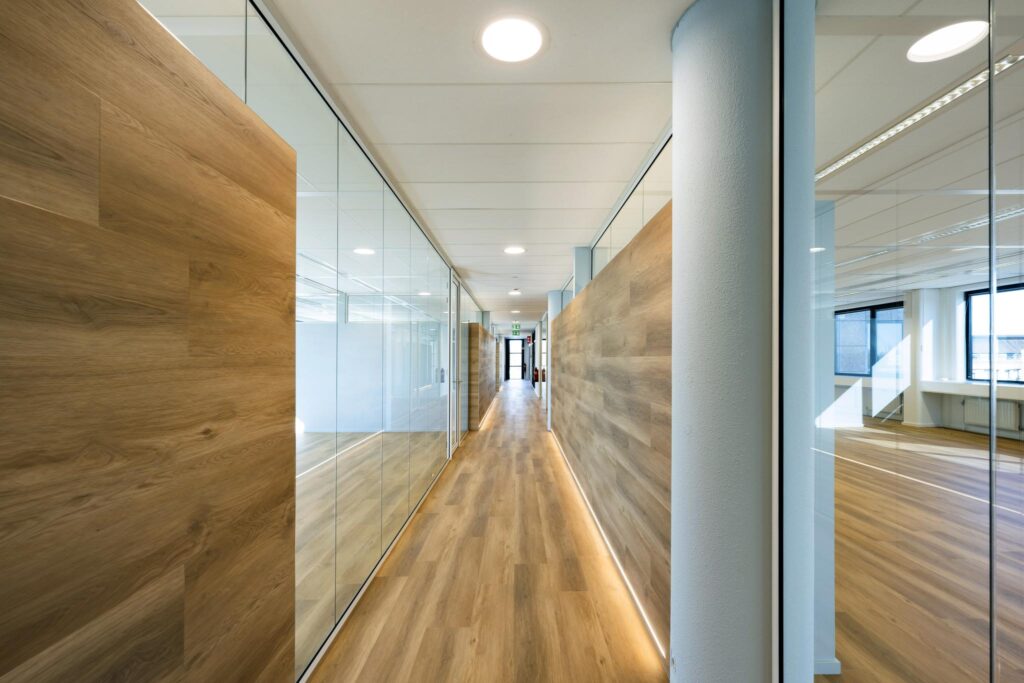 Modern office hallway with wooden floors, glass walls, and natural lighting on Prof. W.H. Keesomlaan.